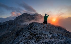 Hiker enjoys view at sunset and mountain Triglav