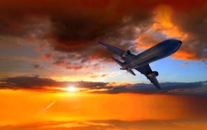 A plane flying in clouds during sunset