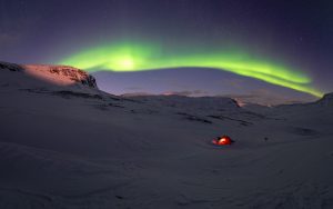 Strong northern lights in the snowy landscape of northern Sweden