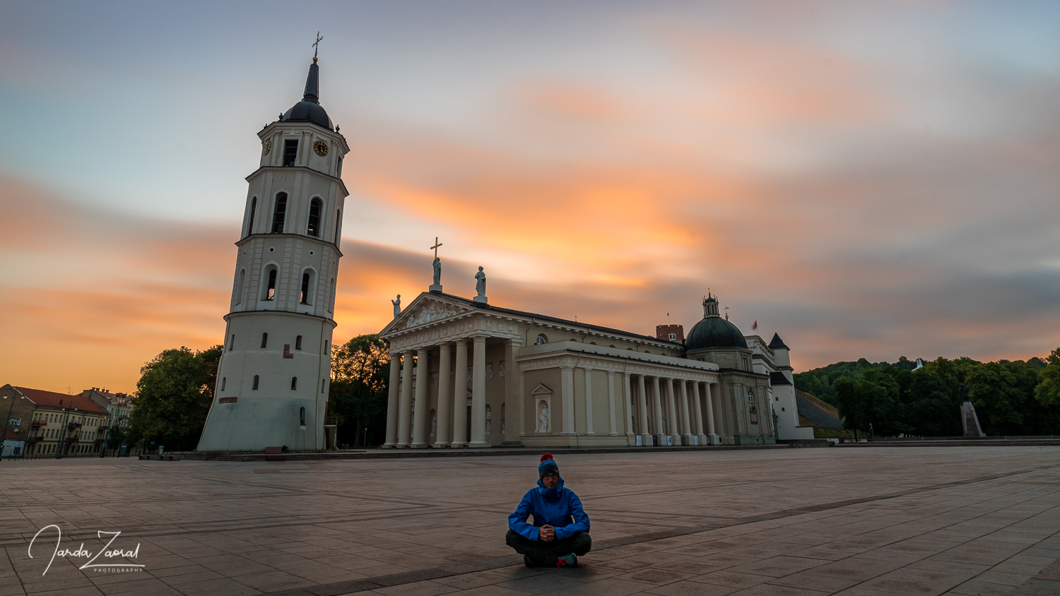 A tourist at Vilnius cathedral during sunrise