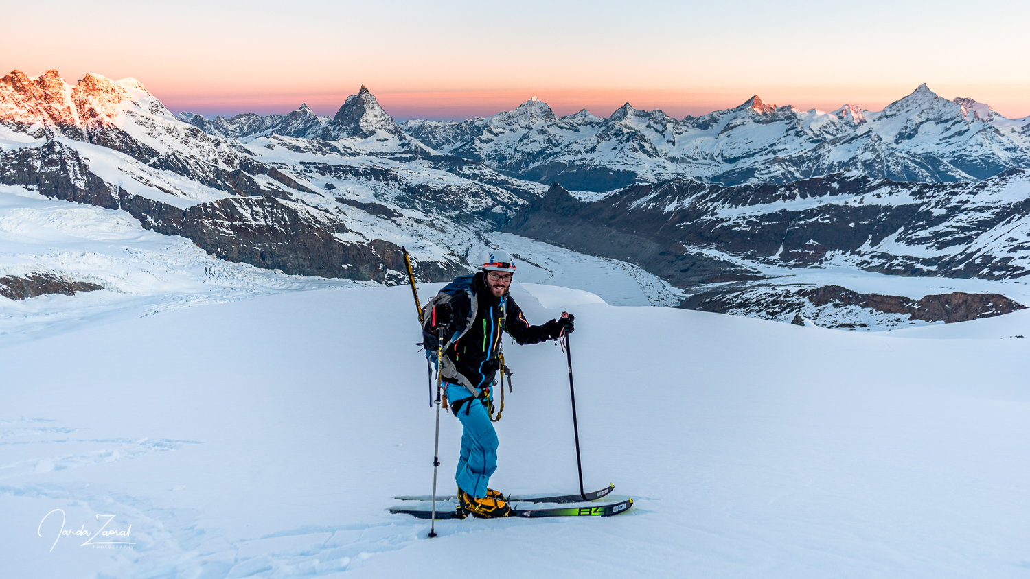 Skier enjoys sunrise and view to Matterhorn and other Swiss mountains