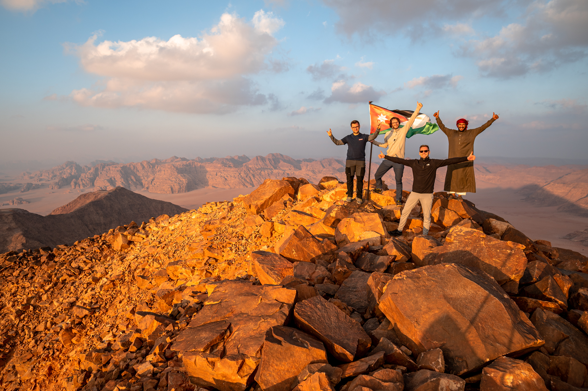 Celebration of successful summit of Jabal Umm ad Dami during sunset