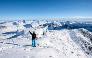 A climber celebrating successful summit of Galdhøpiggen
