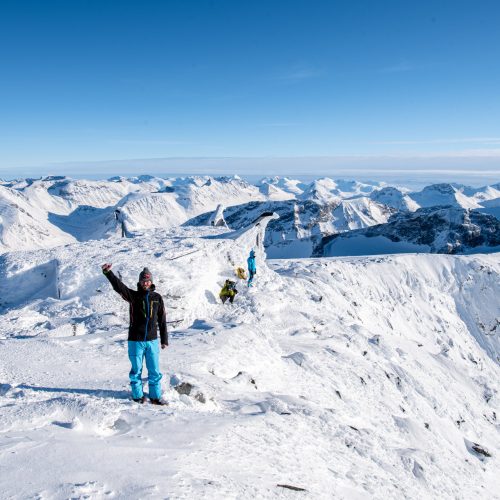 A climber celebrating successful summit of Galdhøpiggen