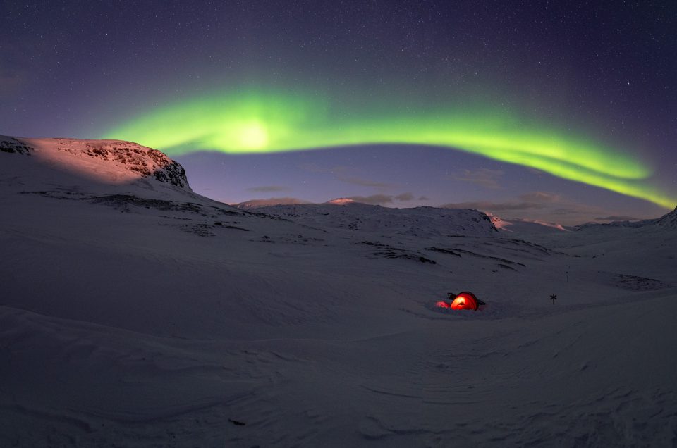 Strong northern lights in the snowy landscape of northern Sweden